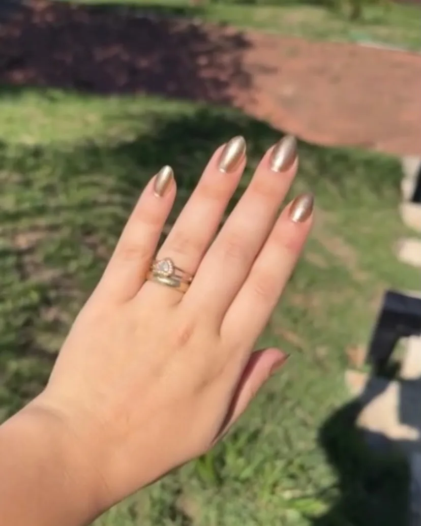 Unhas em dourado metálico, formato amêndoa