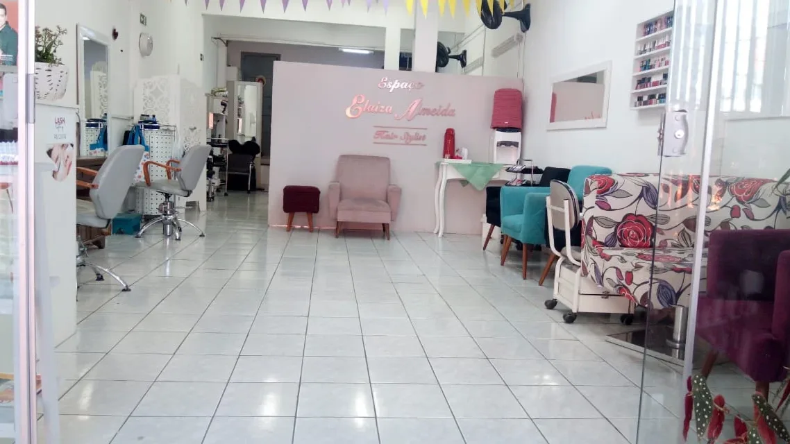 O corredor do salão até a parede com o nome da casa
