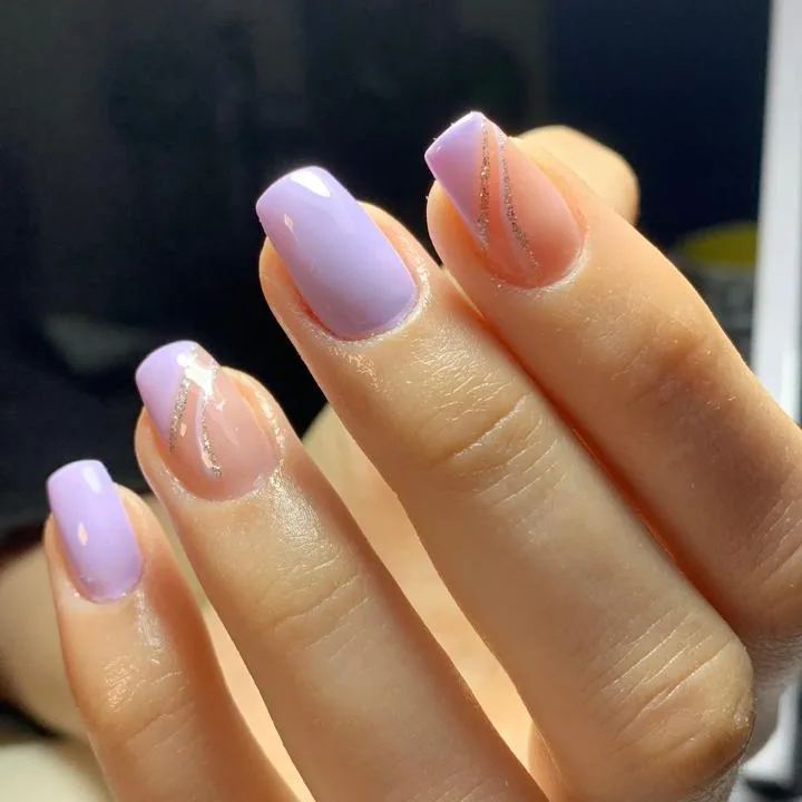 Unhas lilás com detalhes nude e linhas prateadas